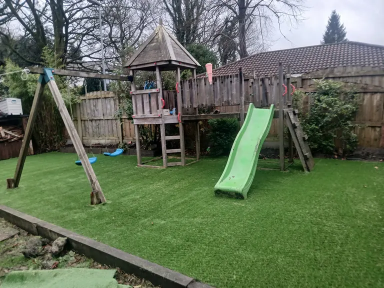 Artificial grass around children’s swings, slide and climbing frame