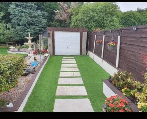 Back garden artificial grass installation with stepping stones in Droylsden, Manchester
