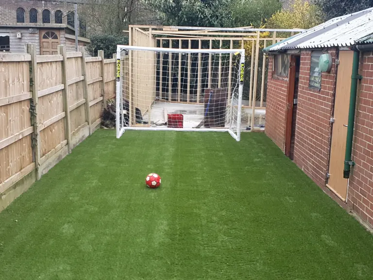 Artificial grass mini football practice area with a goal.