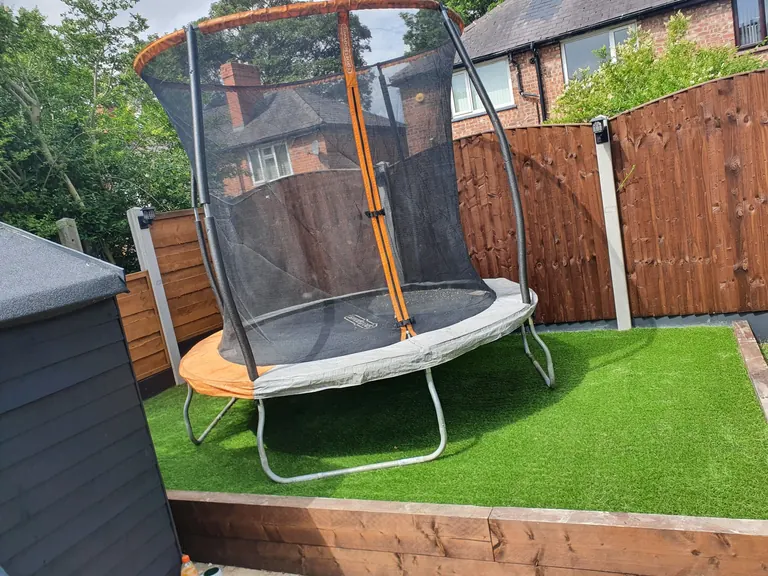 Artificial grass garden around a trampoline.